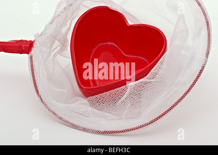 Red heart shaped candy dish in a butterfly net Stock Photo