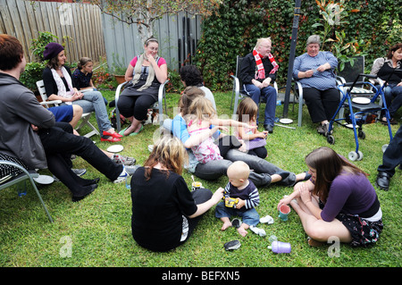 Australians enjoying Easter Sunday with a lunch time party of Hot Cross Buns and drinks in a private home and garden Stock Photo