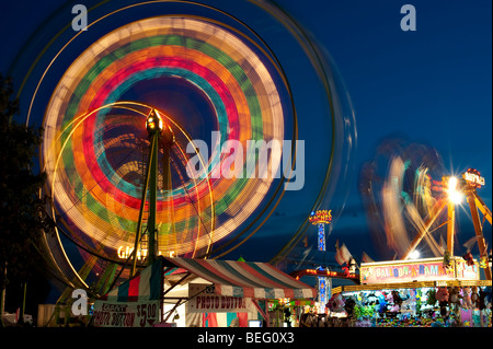 Evergreen State Fair at twilight with Ferris Wheel and amusement rides and game booths at night Monroe Washington State USA Stock Photo