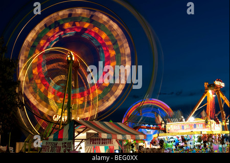 Evergreen State Fair at twilight with Ferris Wheel and amusement rides and game booths at night Monroe Washington State USA Stock Photo