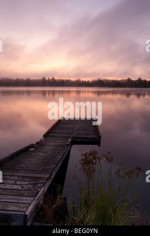 Lake Cassidy sunrise in fog and shoreline and dock Stock Photo