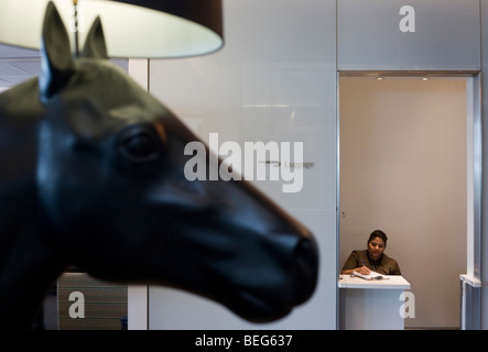 Receptionist and horse artwork in the British Airways Galleries First for First Class passengers at Heathrow airport's T5 Stock Photo