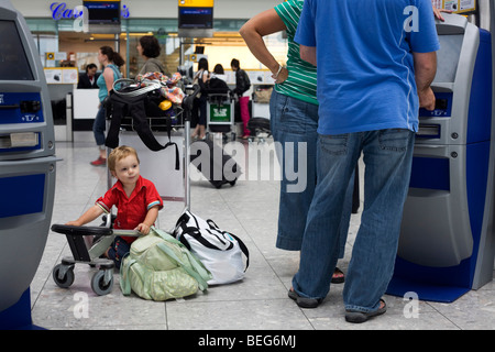 A scene of busy modern air travel as international passengers check-in at the British Airways Heathrow Airport's T5