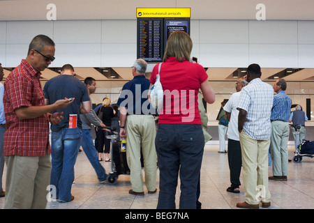Family members and drivers await appearing passengers in international arrivals at Heathrow Airport's Terminal 5. Stock Photo