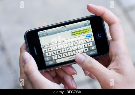 Sending SMS text message on Apple iPhone Stock Photo