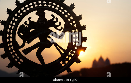 Dancing lord Shiva statue, Nataraja silhouette, against an indian temple sunrise background. Puttaparthi, Andhra Pradesh, India Stock Photo