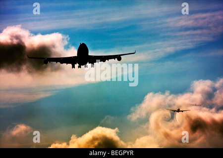 Wake turbulence forms behind aircrafts as they passes through the clouds when descending for landing. Stock Photo