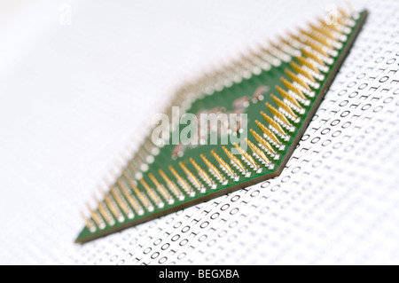 A tilted view of a computer CPU chip on binary code Stock Photo