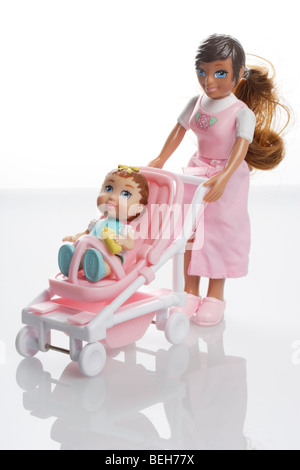 Mother doll with baby girl doll in a miniature pushchair buggy Stock Photo