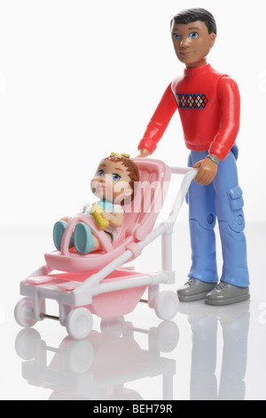 Father doll with baby girl doll in a miniature pushchair buggy Stock Photo