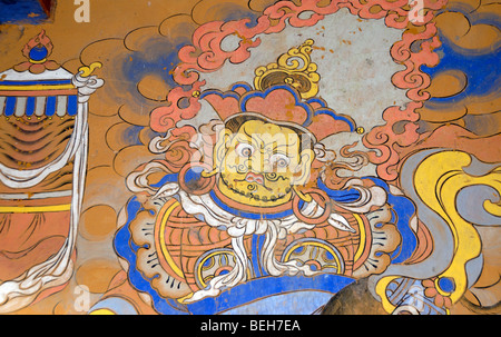 fierce and warlike priest with a victory banner painted in traditional Bhutanese style on a wall in Wangdichholing Dzong Bhutan Stock Photo
