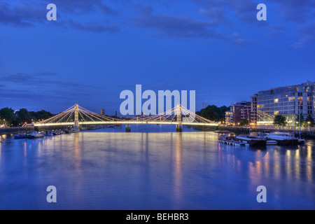 Dusk falls over the River Thames and the Albert Bridge in London England. Stock Photo