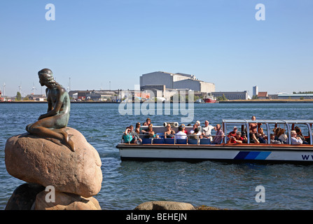 A canal tour cruise boat on a sightseeing tour at The Little Mermaid in the port of Copenhagen, Denmark. Stock Photo