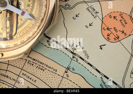An old surveying compass on an out-of-copyright geological research map, showing different rock strata Stock Photo