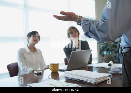 Mid section view of a businessman standing in front of two businesswomen Stock Photo
