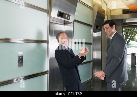 Businessmen laughing in a corridor Stock Photo