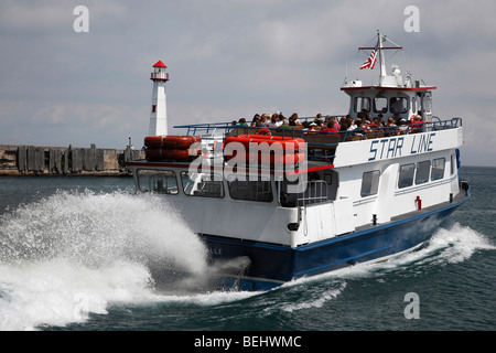 A water splashing Ferry and Wawatam Lighthouse on Lake Huron in Saint Ignace Michigan Great Lakes close up closeup  hi-res Stock Photo