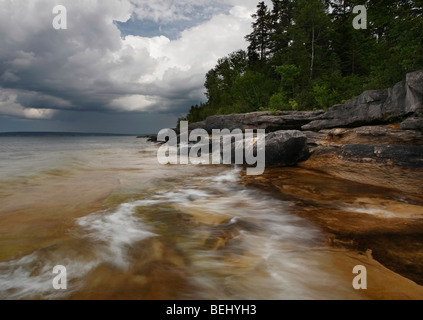 Low angle shot from a lakeshore till the horizon in the sunset under ...