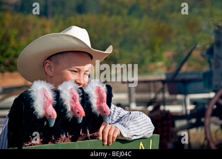 A happy young cowboy poses with three buzzards at the annual Cowboy Symposium in Ruidoso Downs, New Mexico. Stock Photo