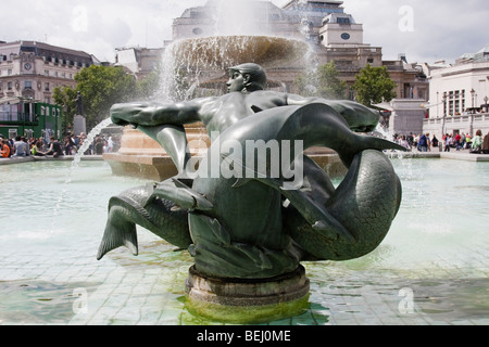Bronze sculpture of merman in trafalgar square, London England, with fountain behind. Taken in summer 2009. Stock Photo