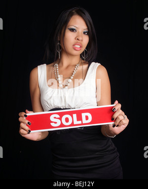 Attractive young business woman holding a sold sign Stock Photo