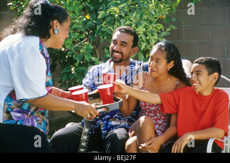 Latin mother father dad kids boy girl child smile enjoy pleased nice love serve offer unselfish generous giving share care Stock Photo