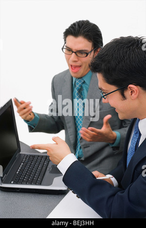 Two businessmen sitting in front of a laptop in a meeting Stock Photo