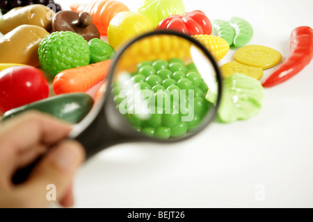 Plastic game, fake varied vegetables and fruits. Children food education toy. Looking with amplifier lens Stock Photo