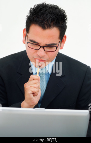 Close-up of a businessman thinking while using a laptop Stock Photo
