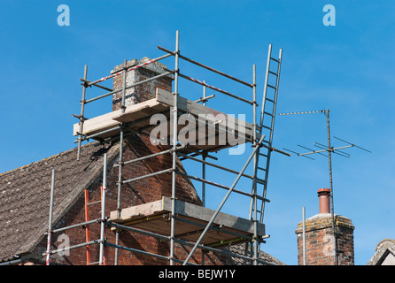 Scaffolding erected for maintenance of roof and chimney stack Stock Photo