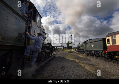 An engine driver climbing into the cab of a steam train on the preserved  Severn Valley Railway at Kidderminster, Shropshire Stock Photo