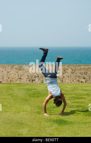 Rear view of a man doing a handstand in a park Stock Photo