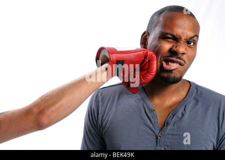 African American man getting hit on face by gloved hand Stock Photo