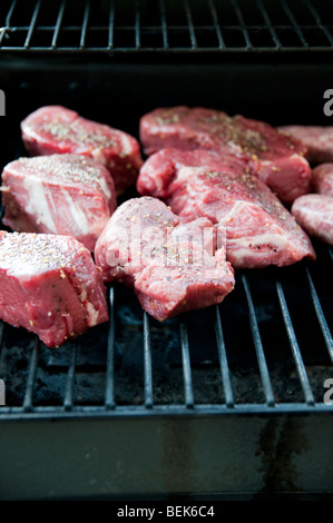 Seasoned Raw Steak Chops on a BBQ Grille Stock Photo