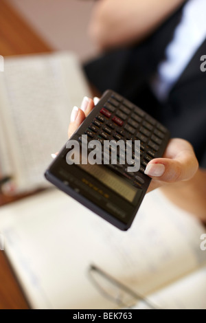 Woman working out finances Stock Photo