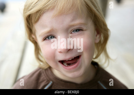 Adorable blond little girl crying closeup portrait Stock Photo