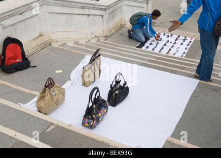 Fake designer handbags for sale. Man setting up fake sunglasses pitch. Venice Italy  2009 2000s HOMER SYKES Stock Photo