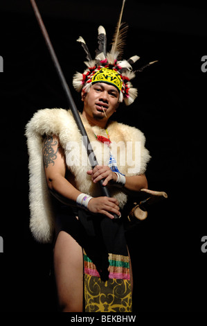 Warrior from the Orang Ulu Tribe in Feathered Head-dress & Animal Skins with Blowpipe Dance Sarawak Malaysia Borneo Stock Photo