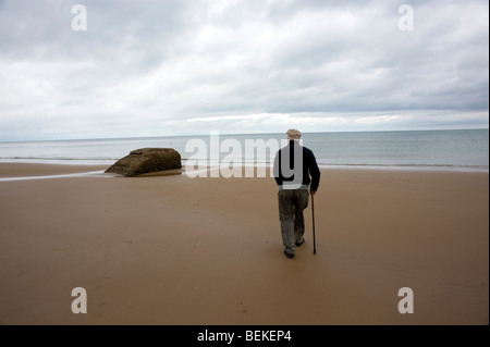 Omaha Beach, Normandy, France. WW2 veteran visits Remains of WW2 D Day German blockhouse ruins on beach. Stock Photo
