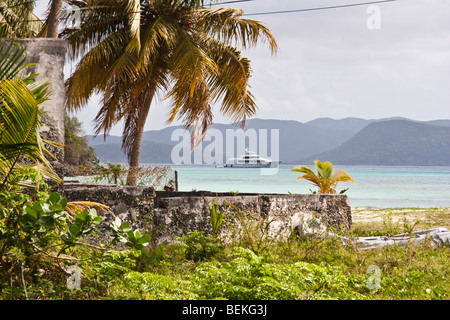View from the shore  of an anchored motor yacht at Great Harbour, Jost Van Dyke; Tortola in the background Stock Photo