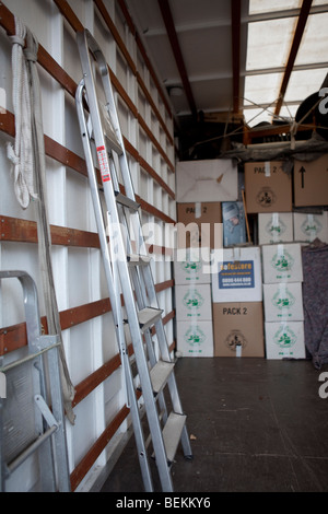 Blankets, step ladders and cartons / boxes inside the back of a removal truck, in the process of moving house. Stock Photo