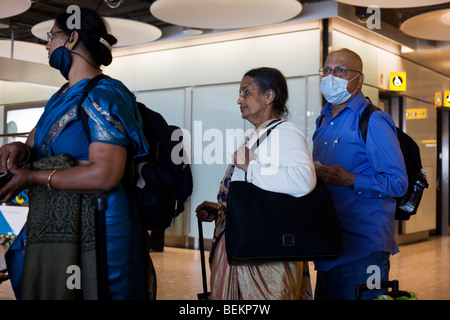 Airline passengers recently arrived from India wait in line at Heathrow Airport's Terminal 5 Stock Photo