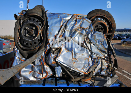 Scrapped motor car crushed into a cube for recycling in car dealers ...