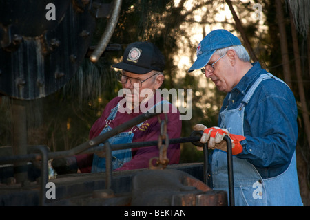 Two engineers working on a 1930s steam locomotive in Florida Stock Photo
