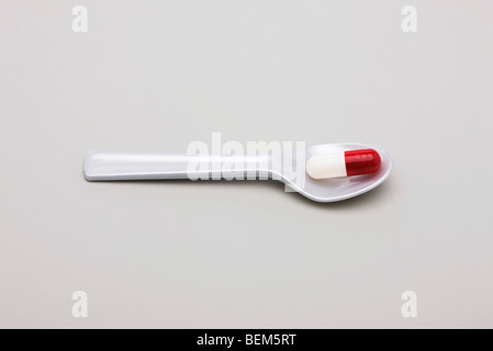 Single pill on spoon Stock Photo