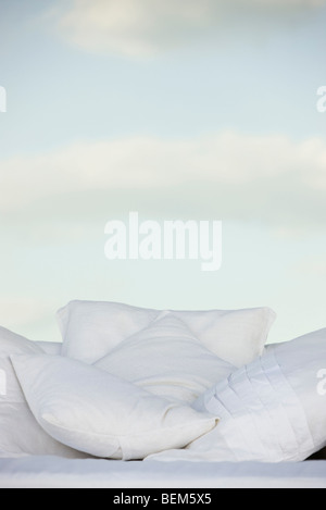 Pillows against background of clouds in pale sky Stock Photo