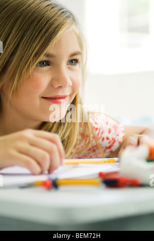 Girl daydreaming at school desk Stock Photo
