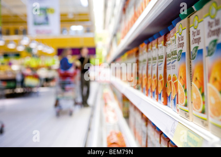 Juice cartons on shelf in supermarket cooler Stock Photo