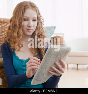 Woman reading ads in paper Stock Photo