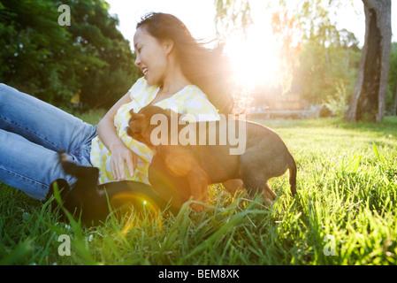 Young woman playing with two puppies outdoors Stock Photo